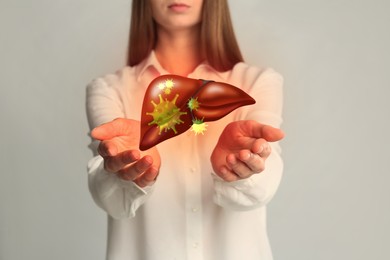 Woman and illustration of unhealthy liver on light grey background. Viral hepatitis