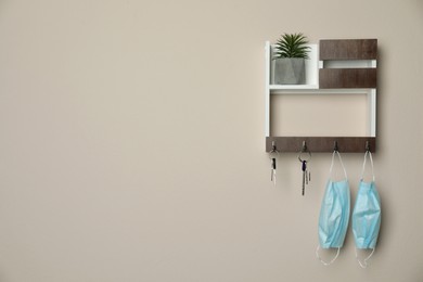 Wooden key holder on beige wall. Space for text