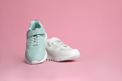 Two stylish sneakers on pink background. Space for text