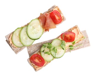 Photo of Tasty crispbreads with cream cheese and fresh vegetables isolated on white, top view