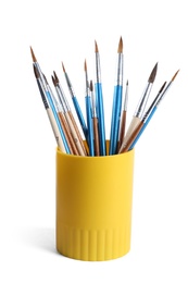 Holder with different paint brushes on white background