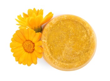 Yellow solid shampoo bar and flowers on white background, top view. Hair care