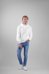 Photo of Full length portrait of man in hoodie sweater on light background. Space for design
