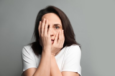 Photo of Mature woman feeling fear on grey background