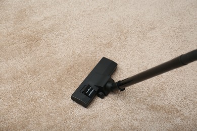 Photo of Removing dirt from carpet with modern vacuum cleaner indoors. Space for text