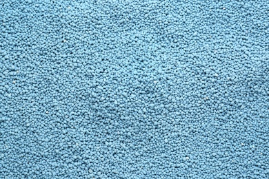 Blue granular mineral fertilizer as background, top view