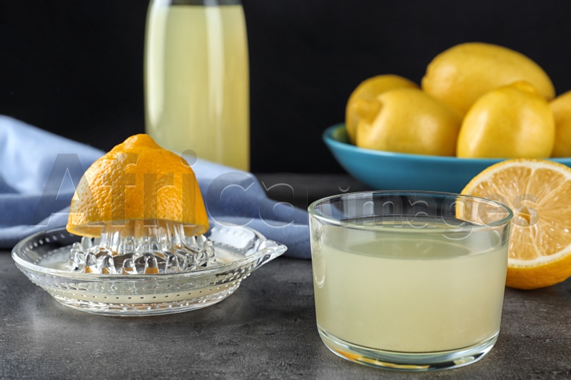 Composition with glass of freshly squeezed lemon juice on table
