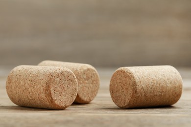 Corks of wine bottles on wooden table, closeup