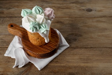 Photo of Traditional Easter cake decorated with meringues on wooden table, space for text