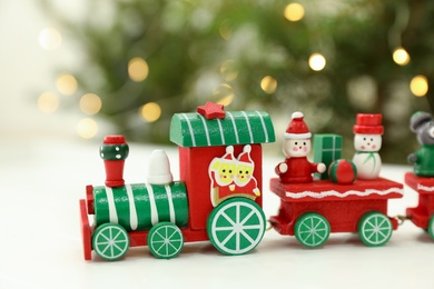 Bright toy train on white table, closeup. Christmas atmosphere