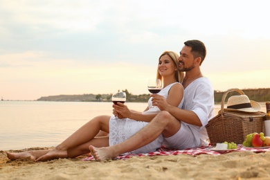Happy romantic couple having picnic at beach