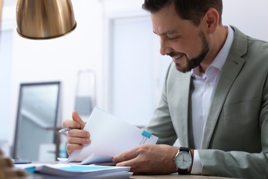Businessman working with documents at table in office