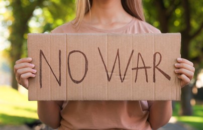Woman holding poster with words No War in park, closeup