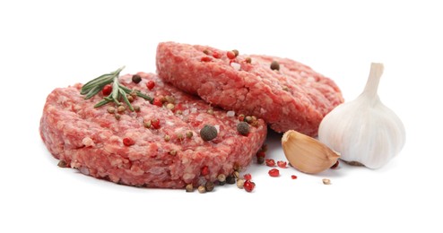 Raw hamburger patties with rosemary, garlic and spices on white background, closeup
