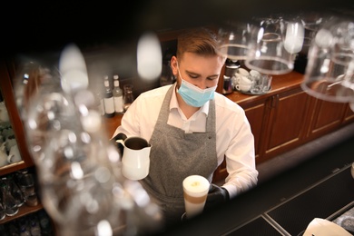 Barista preparing coffee at counter in restaurant. Catering during coronavirus quarantine