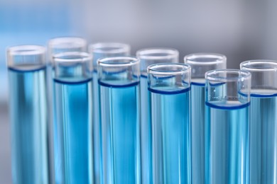 Test tubes with reagents on blurred background, closeup. Laboratory analysis
