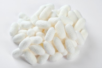 Pile of natural silkworm cocoons on white background, above view
