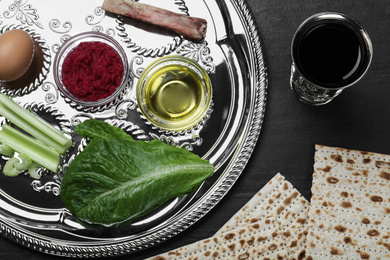 Flat lay composition with Passover Seder plate (keara) on black table. Pesah celebration