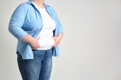 Overweight woman on light background
