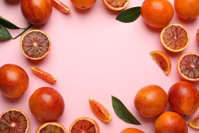 Photo of Frame of ripe sicilian oranges and leaves on pink background, flat lay. Space for text