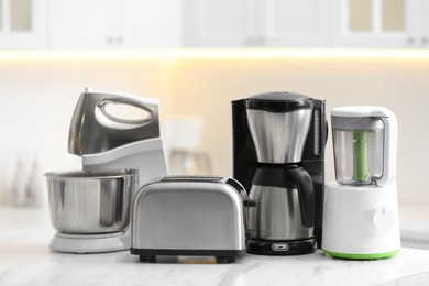 Modern toaster and other cooking appliances on table in kitchen