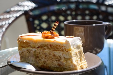 Tasty dessert and cup of fresh aromatic coffee on glass table outdoors, closeup