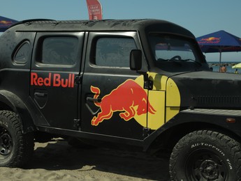 Photo of SENIGALLIA, ITALY - JULY 22, 2022: Red Bull Jeep on beach. Car presentation