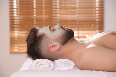 Photo of Man with mask on face lying in spa salon