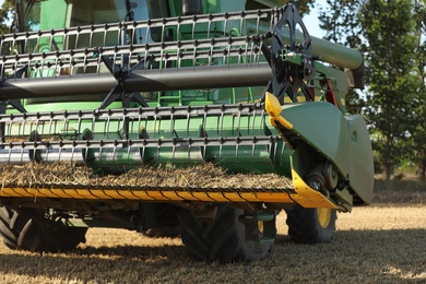 Modern combine harvester in agricultural field, closeup