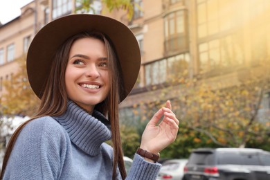 Beautiful young woman wearing stylish autumn clothes on city street