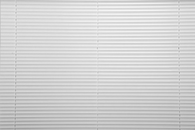 Window with closed white horizontal blinds as background