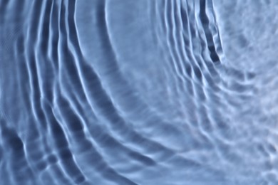 Closeup view of water with rippled surface on blue background