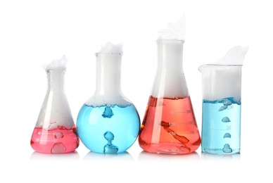Photo of Laboratory glassware with colorful liquids and steam isolated on white. Chemical reaction