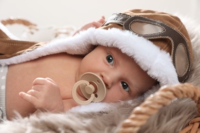 Photo of Adorable newborn baby with pacifier on light background
