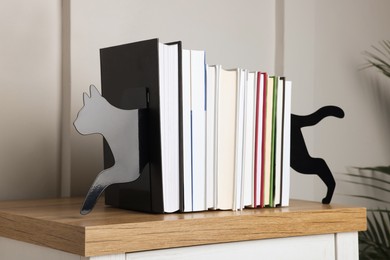 Minimalist cat bookends with books on table indoors