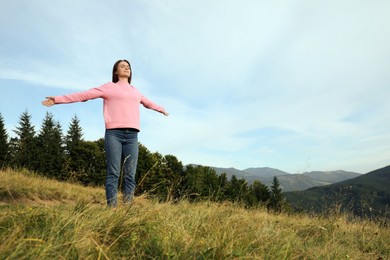 Photo of Young woman enjoying mountain landscape. Space for text