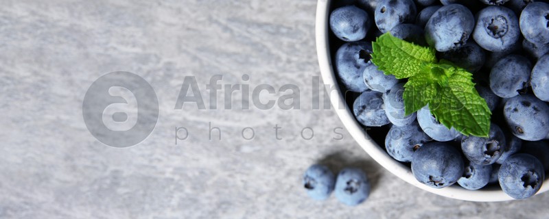 Tasty fresh blueberries on grey table, top view with space for text. Banner design