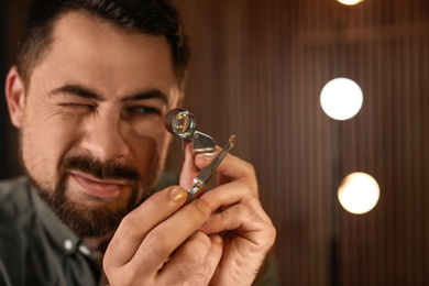 Jeweler working with gemstone on blurred background