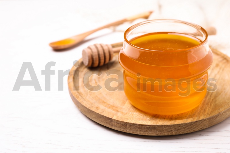 Photo of Tasty aromatic honey on white wooden table