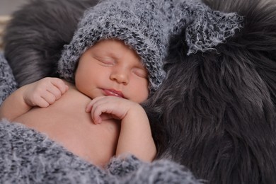 Adorable newborn baby lying on faux fur