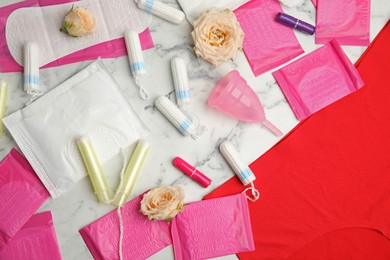 Tampons and other menstrual hygienic products on white marble background, flat lay