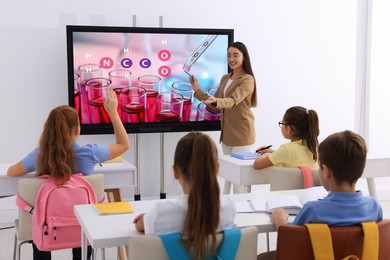 Teacher using interactive board in classroom during lesson