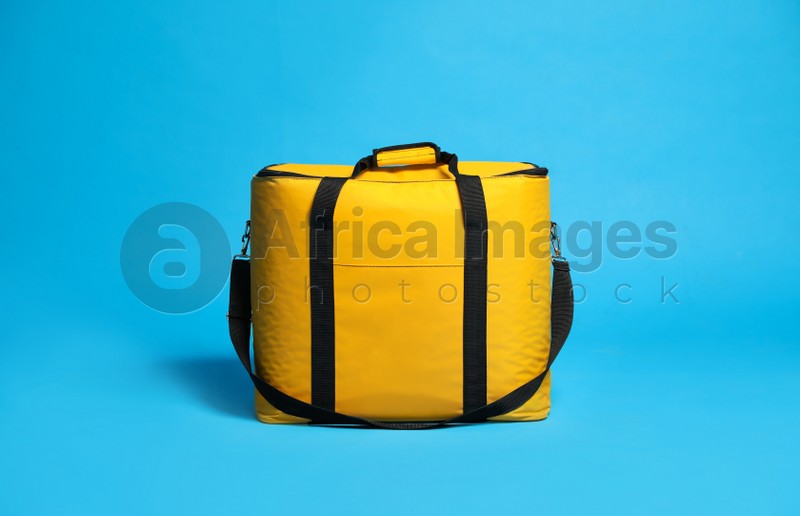 Modern yellow thermo bag on light blue background