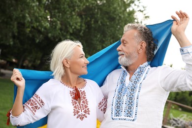 Happy mature couple with national flag of Ukraine outdoors