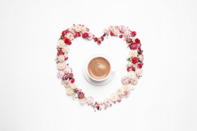 Photo of Beautiful heart shaped floral composition with cup of coffee on light background, flat lay