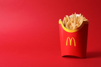 MYKOLAIV, UKRAINE - AUGUST 12, 2021: Big portion of McDonald's French fries on red background. Space for text