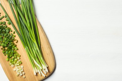 Fresh green onion on white wooden table, top view. Space for text