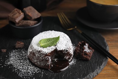Delicious fresh fondant with hot chocolate and mint on wooden table