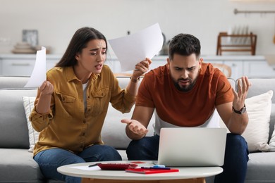 Young couple having argument about family budget at home