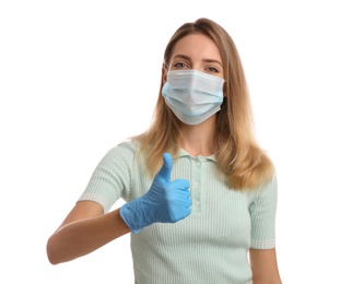 Young woman in medical gloves and protective mask showing thumb up on white background